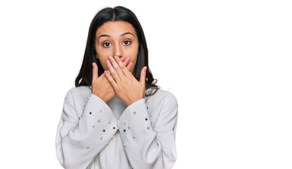 Young hispanic girl wearing casual clothes shocked covering mouth with hands for mistake. secret concept. 