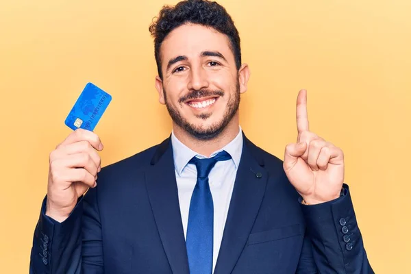 Νεαρός Ισπανός Που Φοράει Κοστούμι Κρατώντας Πιστωτική Κάρτα Χαμογελώντας Μια — Φωτογραφία Αρχείου