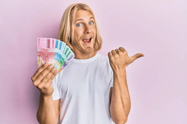 Kafkasyalı Uzun Saçlı Elinde Endonezya Rupiası Banknotları Olan Genç Bir — Stok fotoğraf