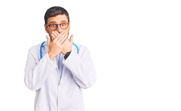 Joven Guapo Con Oso Vistiendo Uniforme Médico Impactado Cubriendo Boca —  Fotos de Stock