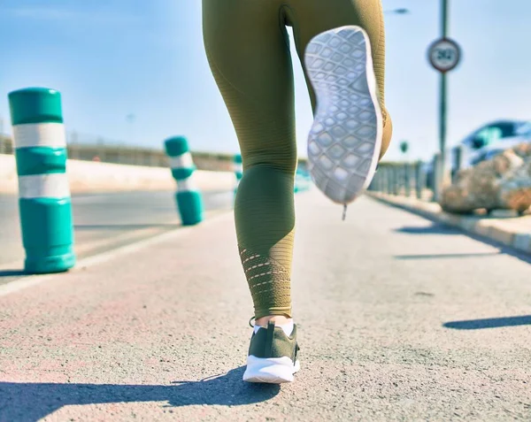 Sportswoman wearing sportswear running at the city.