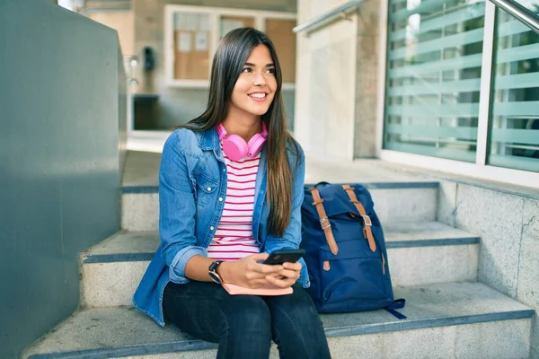 Νεαρή Ισπανόφωνη Μαθήτρια Χαμογελά Ευτυχισμένη Χρησιμοποιώντας Smartphone Στο Πανεπιστήμιο — Φωτογραφία Αρχείου