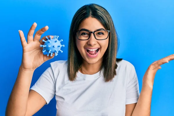 Młoda Latynoska Kobieta Trzyma Zabawkę Wirusa Świętując Zwycięstwo Szczęśliwym Uśmiechem — Zdjęcie stockowe