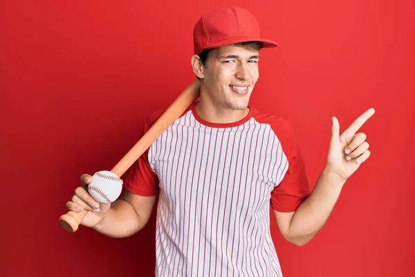 サイドに手と指で幸せなポインティングでバットとボールの笑顔を保持野球をプレイハンサムな原因アジアの男 — ストック写真
