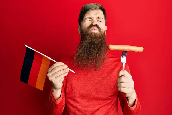 Рыженький Длинной Бородой Держащий Вилку Свиной Колбасой Германским Флагом Смотрящий — стоковое фото
