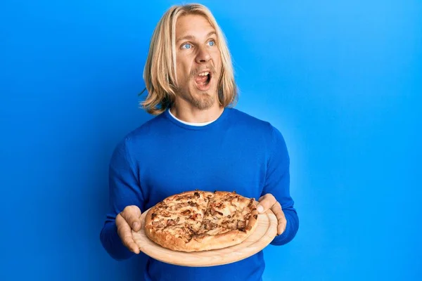Caucasian Young Man Long Hair Holding Italian Pizza Angry Mad — Stock Photo, Image