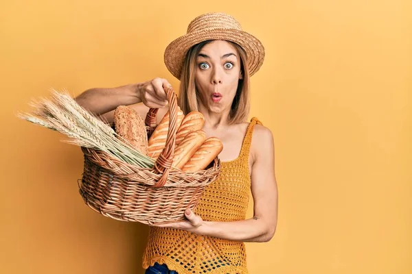 Jovem Mulher Loira Caucasiana Segurando Cesta Vime Com Pão Assustado — Fotografia de Stock