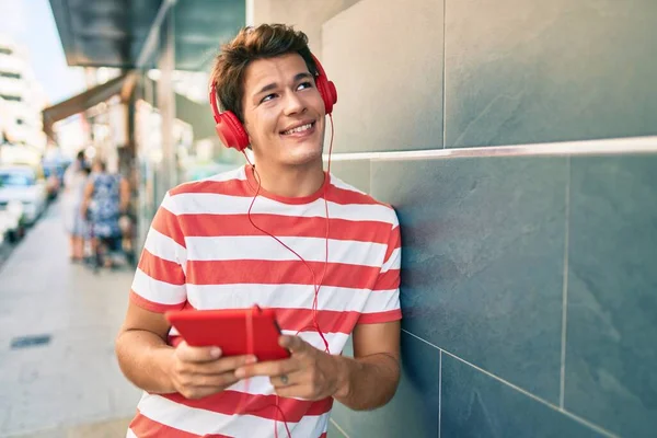 Νεαρός Καυκάσιος Άνδρας Χαμογελά Χαρούμενος Χρησιμοποιώντας Touchpad Και Ακουστικά Στην — Φωτογραφία Αρχείου