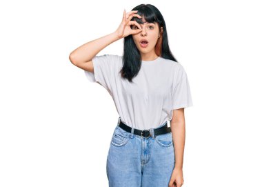 Günlük kıyafetler giyen genç İspanyol kız şaşırmış yüz ifadesiyle şok olmuş, parmaklarından bakan gözler. İnançsız ifade. 