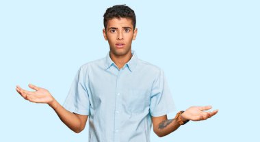 Genç, yakışıklı, Afro-Amerikalı sıradan kıyafetler giyen, habersiz ve kolları açık, hiçbir fikri olmayan bir adam.. 