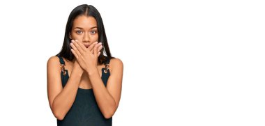 Gündelik kıyafetler giyen güzel İspanyol kadın yanlışlıkla elleri ile ağzını kapatırken şok oldu. gizli kavram. 