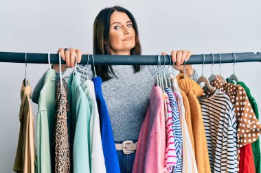Middle age brunette woman working as professional personal shopper clueless and confused expression. doubt concept. 