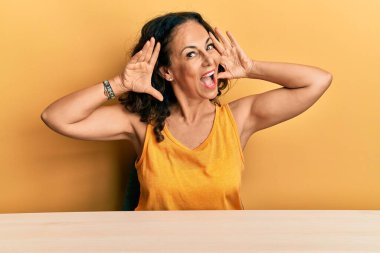 Masada oturmuş güler yüzlü gülümseyen, elleri görünen orta yaşlı, güzel bir kadın. Şaşırdım ve çıktım. 