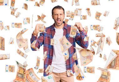 Kızgın ve kızgın giyinmiş genç yakışıklı bir adam öfkeyle bağırırken kızgın ve öfkeli yumruklar sallıyor. öfke ve agresif konsept.