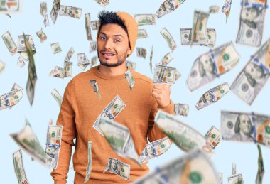 Yakışıklı Latin Amerikalı genç adam. Kış süveteri ve yün şapka giyiyor. Gülümsüyor, gülümsüyor..