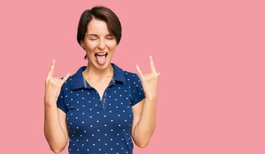 Kısa saçlı, sıradan kıyafetler giyen, çılgın bir ifadeyle bağıran, elleri havada rock sembolü yapan genç esmer kadın. Müzik yıldızı. ağır kavram. 