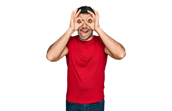 Hispanic Man Beard Wearing Casual Red Shirt Doing Gesture Binoculars — Stock Photo, Image