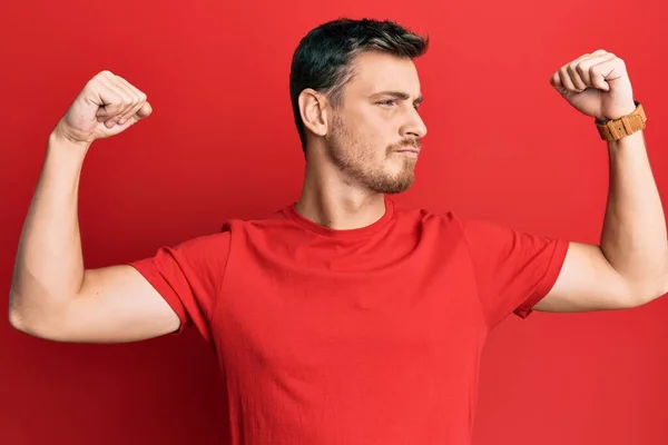 Handsome Caucasian Man Wearing Casual Red Tshirt Showing Arms Muscles — Fotografia de Stock