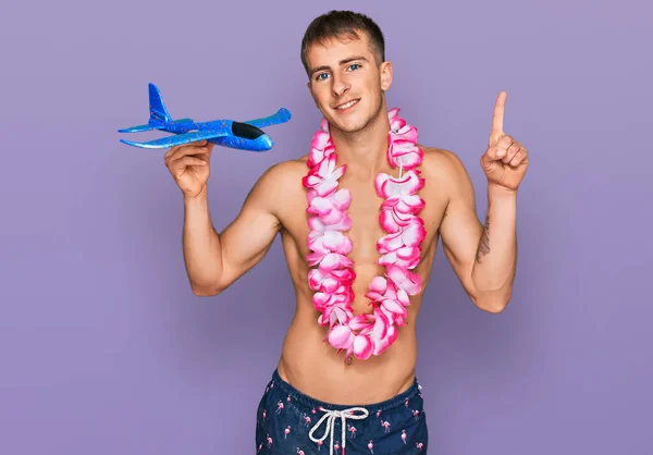 Young Blond Man Wearing Swimsuit Hawaiian Lei Holding Airplane Toy — Foto de Stock