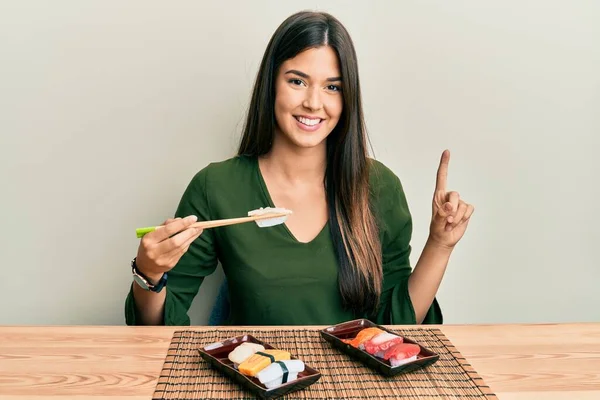 Joven Morena Comiendo Sushi Sentada Mesa Sonriendo Con Una Idea — Foto de Stock