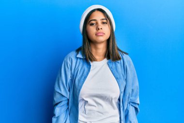 Tatlı yün şapka takan genç Latin kadın uykulu ve yorgun görünüyor, yorgunluktan bitkin ve akşamdan kalma, sabahları tembel gözler.. 