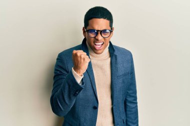 Zarif kıyafetler giyen, gözlüklü, kızgın ve kızgın genç, yakışıklı, sinirli ve öfkeliyken öfkeyle bağıran bir adam. öfke ve agresif konsept. 