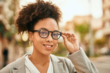 Genç Afrikalı Amerikalı iş kadını şehirde mutlu bir şekilde dikiliyor..