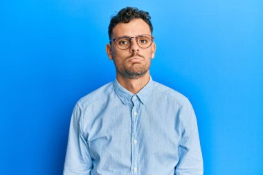 Gündelik kıyafetler ve gözlük takan genç İspanyol adam üzgün ve endişeli, sinirli ve korkmuş. hüzünlü ifade. 