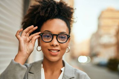 Genç Afrikalı Amerikalı iş kadını şehirde mutlu bir şekilde dikiliyor..