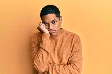 Genç, yakışıklı, sıradan bir süveter giyen, depresyondan sıkılmış ve yorgun görünen, kollarını kavuşturmuş bir İspanyol.. 