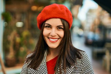 Genç İspanyol kadın gülümseyerek şehirde mutlu mesut dikiliyor..