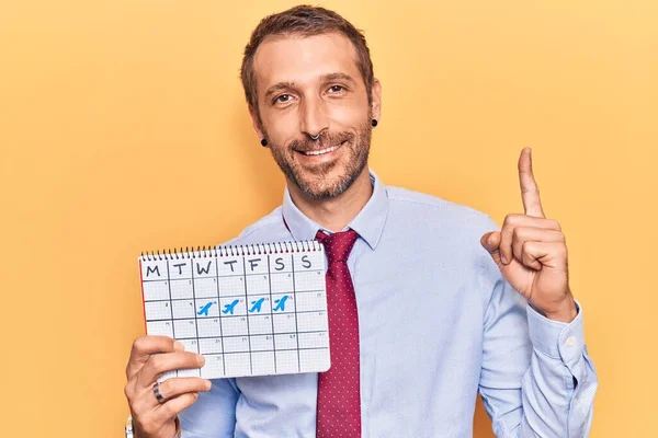 Joven Hombre Guapo Sosteniendo Calendario Viaje Sonriendo Con Una Idea —  Fotos de Stock