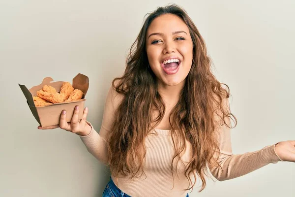 Young Hispanic Girl Eating Chicken Wings Celebrating Achievement Happy Smile — Fotografia de Stock