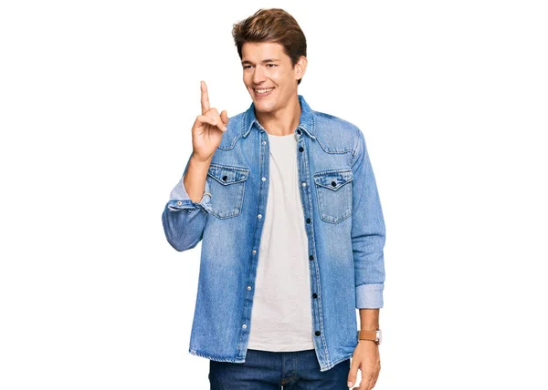 Handsome Caucasian Man Wearing Casual Denim Jacket Showing Pointing Finger — Fotografia de Stock