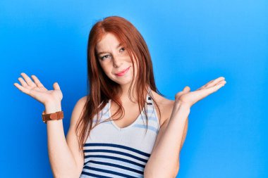 Gündelik kıyafetler giyen genç kızıl saçlı kız, habersiz ve kolları açık, hiçbir fikrim yok ve şüpheli bir yüzüm var.. 