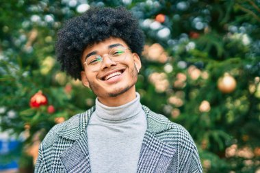 Genç Afrikalı Amerikalı işadamı parkta mutlu bir şekilde dikiliyor..