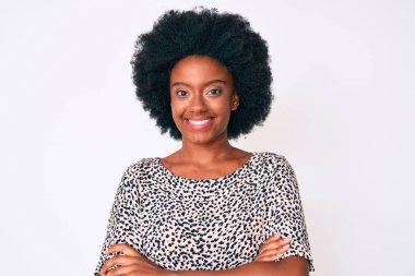 Sıradan kıyafetler giyen, kollarını kavuşturup kameraya gülümseyen genç Afrikalı Amerikalı kadın. pozitif kişi. 