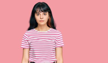 Günlük kıyafetler giyen genç İspanyol kız yüzünde ciddi bir ifadeyle rahatlamış. Basit ve doğal bir şekilde kameraya bakıyorsun.. 