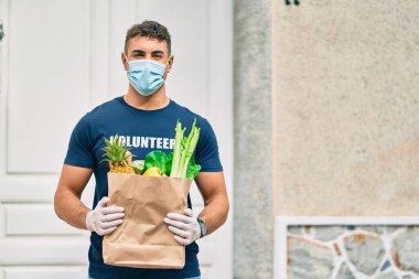 Şehirde tıbbi maske takan genç İspanyol gönüllü adam..