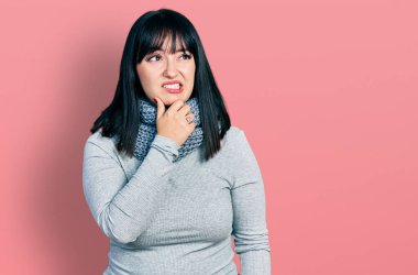 İspanyol asıllı, uzun boylu, kış eşarbı takan bir kadın bir soru hakkında endişeli ve gergin bir şekilde düşünüyor. 