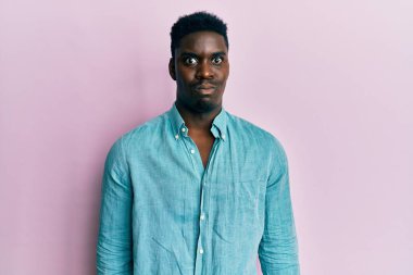 Sıradan kıyafetler giyen yakışıklı siyah adam komik yüzlü yanakları şişiriyor. Havayla şişmiş ağız, çılgın bir ifade.. 