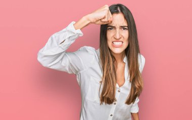 Genç, güzel bir kadın, kızgın ve kızgın. Öfkeyle bağırırken yumruğunu sallıyor ve öfkeleniyor. öfke ve agresif konsept. 