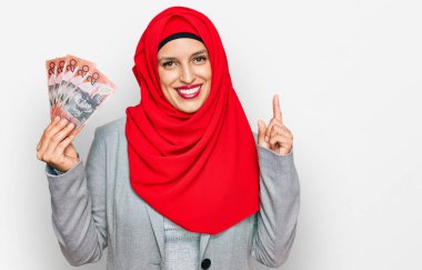 İslami tesettüre bürünmüş güzel İspanyol kadın elinde Avustralya doları banknotları bir fikir ya da soru işareti ile şaşırdı. 