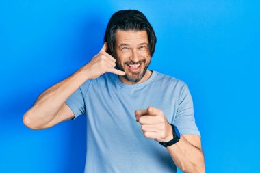 Orta yaşlı, günlük kıyafetler giyen, gülümseyen, telefonla konuşan ve seni işaret eden beyaz bir adam. Ara beni.. 