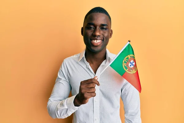 Młody Afrykański Amerykanin Trzymający Portugalską Flagę Wyglądający Pozytywnie Szczęśliwie Stojący — Zdjęcie stockowe