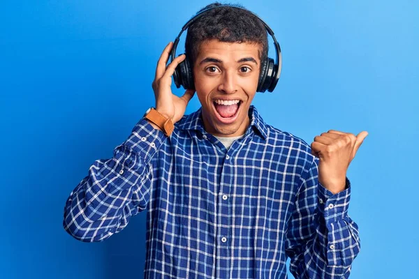 Joven Africano Amerciano Escuchando Música Usando Auriculares Apuntando Con Pulgar —  Fotos de Stock