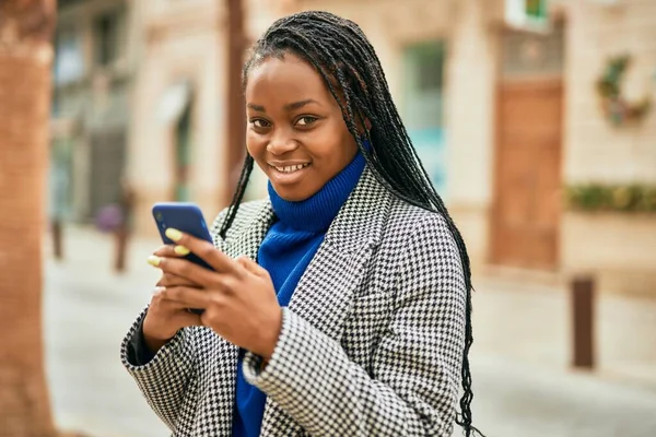 年轻的非洲裔美国女商人在城市里用智能手机开心地笑着 — 图库照片