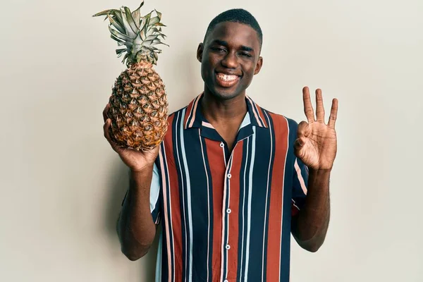 Молодой Африканский Американец Ананасом Делает Знак Пальцами Улыбаясь Дружелюбный Жест — стоковое фото