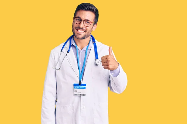 Jovem Hispânico Vestindo Uniforme Médico Estetoscópio Fazendo Polegares Felizes Gesto — Fotografia de Stock