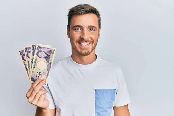 Handsome Caucasian Man Holding 5000 Japanese Yen Banknotes Looking Positive —  Fotos de Stock